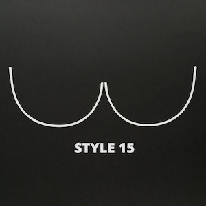 May include: Two white metal bra underwire cups, curved and joined at the center, on a black background. The text "STYLE 15" is printed below the cups.