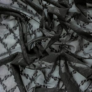 Könnte beinhalten: Schwarzer, durchsichtiger Stoff mit einem zarten Blumenmuster. Der Stoff ist weich und leicht, wodurch er sich perfekt für eine Vielzahl von Projekten eignet.