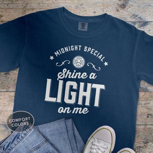 May include: A set of three ceramic mugs with a speckled, matte finish. The mugs are in shades of cream, light gray, and dark gray. Each mug has a simple, minimalist design and a rounded handle. The mugs are likely for coffee or tea.