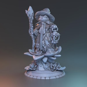 Puede incluir: Una detallada figura gris de un mago rana. El mago lleva un sombrero y una capa, sosteniendo un bastón con punta de cristal y una linterna. La figura se alza sobre una base floral con intrincados detalles.