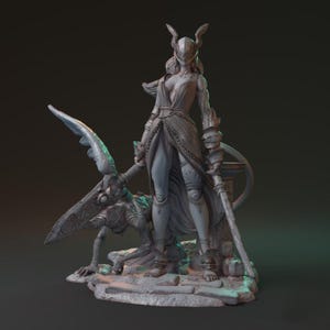 May include: A detailed gray figurine of a warrior woman in armor, holding a sword and standing over a creature. The woman wears a helmet with horns and a flowing gown. The sculpture is on a rocky base.