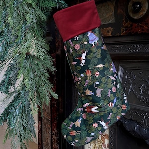 May include: A Christmas stocking featuring a dark green fabric base with a repeating pattern of nutcracker figures, mice, lollipops, and ornaments. The stocking has a solid deep red cuff at the top and is displayed hanging vertically.