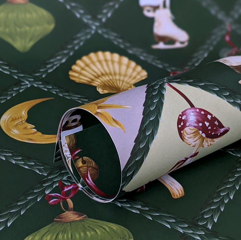 May include: Dark green wallpaper featuring a repeating pattern of gold ornaments, seashells, moons, and mushrooms. The wallpaper is rolled, revealing a cream interior with more illustrations. The design includes a diamond-shaped trellis.