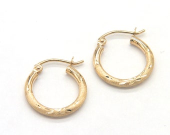 May include: A pair of gold hoop earrings with a textured finish. The earrings are 15mm in diameter.