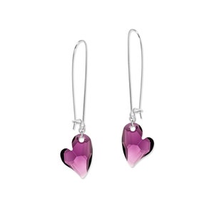 May include: A pair of silver dangle earrings with purple heart-shaped crystal charms.
