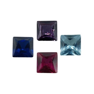 May include: Four square-shaped gemstones in different colors: blue, purple, red, and light blue.