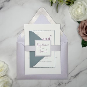 May include: A lavender envelope with a white inner envelope and a gray card with the text "Stephanie and Daniel" in purple script. The card is decorated with a gray and white ribbon.