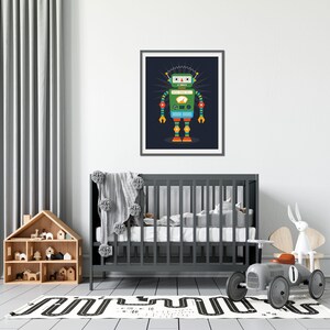 K&ouml;nnte beinhalten: Eine bunte Roboterillustration in einem schwarzen Rahmen, die an einer wei&szlig;en Wand &uuml;ber einem grauen Kinderbett in einem Kinderzimmer h&auml;ngt. Der Roboter hat einen gr&uuml;nen K&ouml;rper, blaue Beine und rote, gelbe und blaue Akzente. Der Roboter steht auf einem dunkelblauen Hintergrund mit einem wei&szlig;en Stern dahinter.
