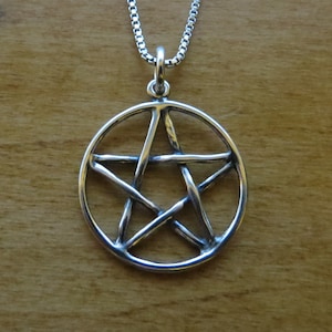 May include: A silver pendant necklace featuring a pentacle, a five-pointed star within a circle, with a detailed, woven design.