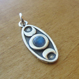 May include: Silver pendant with three crescent moons and a blue labradorite gemstone in the center.