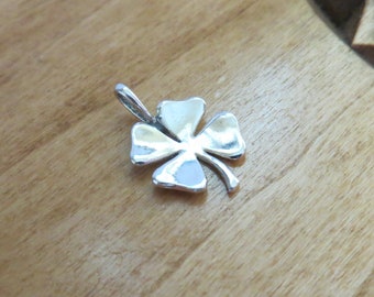 May include: A silver four-leaf clover charm pendant.