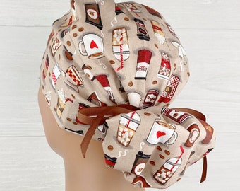 May include: A brown and beige scrub hat with a coffee cup and beverage print. The hat has a brown ribbon tie.