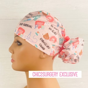 May include: Pink surgical scrub hat with a fun print featuring intestines, poop emojis, and the text "Crap Happens", "No Guts, No Glory", and "Endoscopy Squad".