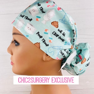 May include: A light blue surgical scrub hat with a white tie. The hat has a fun print with cartoon images of toilets, poop, and the text "Poop Troop" and "Crap Done".