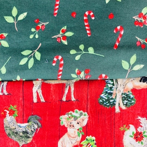 May include: Two folded pieces of fabric. The top fabric is dark green with a pattern of red and white candy canes, green leaves, and red berries. The bottom fabric is red with a wood grain texture, featuring illustrations of a rooster, a pig wearing a wreath, a hen, and gifts.