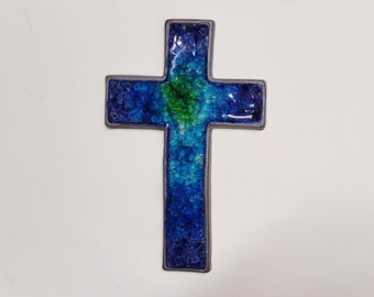 Könnte beinhalten: Ein blaues und grünes Buntglaskreuz mit einem grauen Rand.