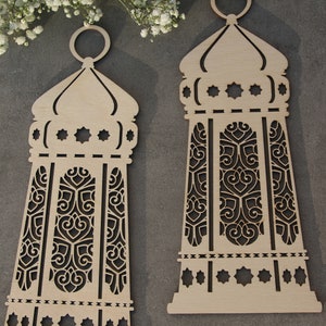 May include: Two wooden decorative lanterns with intricate cut-out designs. The lanterns are light brown and have a traditional Moroccan style.