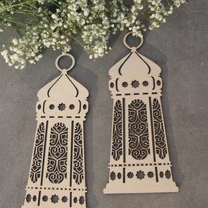 May include: Two wooden decorative lanterns with intricate cut-out designs. The lanterns are beige and have a traditional Islamic style.