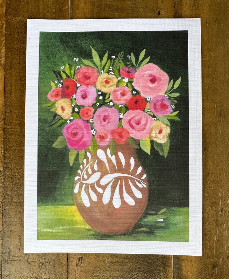 May include: A floral painting featuring a brown vase with white decorative accents, filled with a bouquet of pink, red, and yellow roses and green leaves. The background is a dark green with a lighter green base.