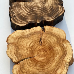 Puede incluir: Dos rebanadas de madera con patrones naturales de veta de madera. La rebanada superior es de color marr&oacute;n oscuro con un acabado quemado. La rebanada inferior es de color marr&oacute;n claro con un acabado de madera natural.