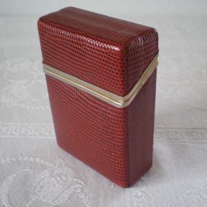 Porta-cigarros vintage Tremblay com aba, unissex, década de 1960 - fabricado na França - couro de lagarto marrom-avermelhado - detalhes em metal - compartimento para cartão - excelente opção de presente.