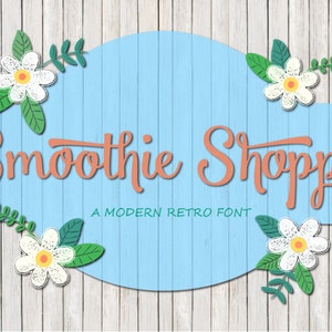 May include: A blue and white sign with the text "Smoothie Shoppe" in a modern retro font. The sign is decorated with white flowers and green leaves.