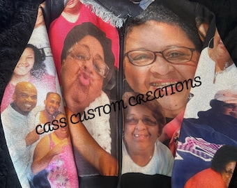 May include: A black zip-up hoodie featuring a collage of smiling faces. The images are printed on the fabric, creating a unique and personalized design. The text "cass CUSTOM CREATIONS" is printed on the front of the hoodie.