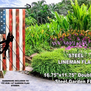 May include: A double-sided garden flag featuring a silhouette of a lineman working on a power line, superimposed on an American flag design with a distressed woodgrain background. The flag is 16.75 inches by 11.75 inches and is made of steel. The text "STEEL LINEMAN FLAG" is printed below the flag.