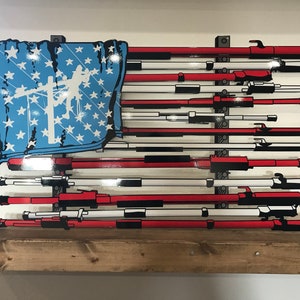 May include: A red, white, and blue American flag made of tools. The flag is made of a variety of tools, including wrenches, screwdrivers, and pliers. The flag is hanging on a wooden wall.