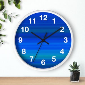 May include: A white clock with black hands and blue and green gradient stripes. The numbers 1 through 12 are printed in white on the clock face.