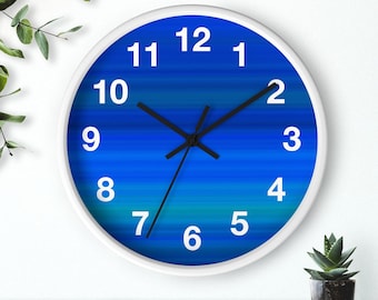 May include: A white clock with black hands and blue and green gradient stripes. The numbers 1 through 12 are printed in white on the clock face.