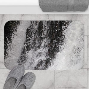 May include: A black and white bathroom rug with a waterfall design. The rug is made of a soft, absorbent material and is perfect for adding a touch of nature to your bathroom.