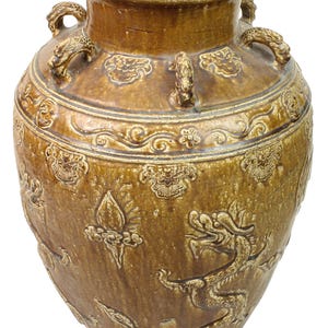 May include: A large, brown ceramic vase with intricate dragon and floral designs. The vase has four handles and a wide mouth.