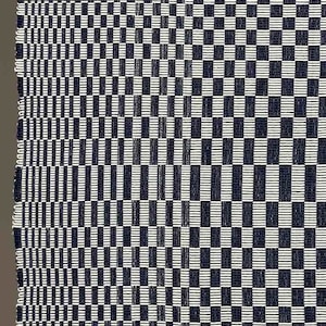 May include: A black and white checked fabric with a woven pattern. The fabric has a subtle sheen and a slightly textured surface.