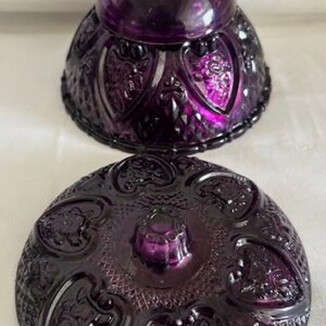 Puede incluir: Un platito de caramelo de vidrio morado vintage con una tapa abovedada. El plato y la tapa est&aacute;n decorados con un patr&oacute;n de coraz&oacute;n.