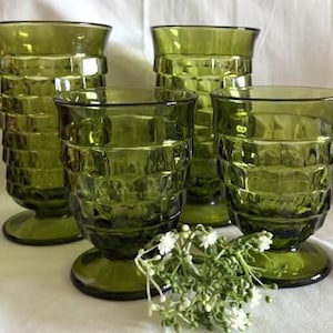 May include: Set of four green glass tumblers with a textured, checkered pattern. The tumblers have a footed base.