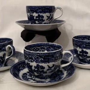 May include: Set of four blue and white teacups and saucers with a traditional Chinese pattern.