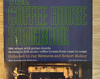 May include: Vintage "The Coffee House Songbook" with green text on a blue background. The book cover features the title, details about the songs, and a black and white image of a coffee house performance.
