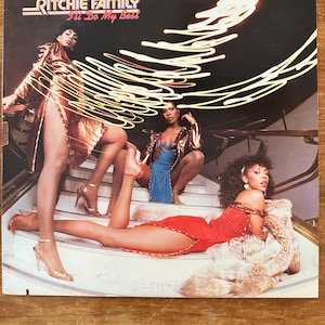 Puede incluir: Una taza de cerámica blanca con un asa negra y el texto "But First, Coffee" en negro, con una fuente de estilo manuscrito. La taza está sobre una superficie blanca.