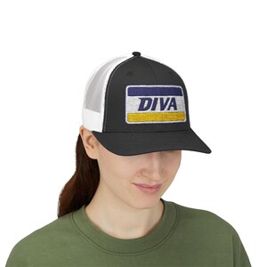 Può includere: Cappellino da camionista nero con retro in rete bianca. Il pannello frontale presenta una toppa rettangolare con la scritta "DIVA" in bianco, sopra un disegno blu e giallo. Il cappello è indossato da una persona con una maglietta verde.