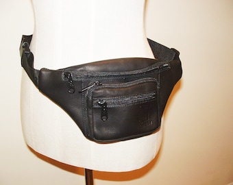 May include: Black leather fanny pack with a zippered pocket and a small logo that says "Genuine Leather".