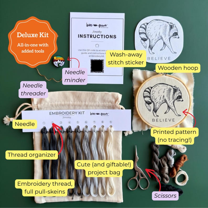 May include: A deluxe embroidery kit containing a wooden hoop with a raccoon pattern, a needle minder, a wash-away stitch sticker, a thread organizer with nine shades of embroidery thread, a needle threader, scissors, and a beige project bag.