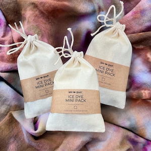 May include: Three small white fabric bags with brown labels that say "Ice Dye Mini Pack" and the color story name. The bags are on a tie-dye fabric background.