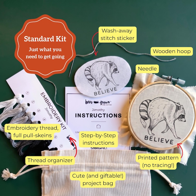 May include: An embroidery kit containing a wooden hoop with a raccoon pattern, a wash-away stitch sticker, embroidery thread on an organizer, a needle, step-by-step instructions, and a drawstring project bag. The kit is labeled Standard Kit.