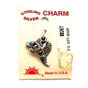 Puede incluir: Encanto de plata de ley con una piedra turquesa, con forma de pájaro con las alas extendidas. El encanto está en una tarjeta blanca con el texto "Sterling Silver Charm", "8826T", "E's Gift Shop" y "Made in U.S.A."
