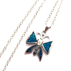 May include: A silver butterfly pendant necklace with turquoise inlay. The butterfly has detailed wings and a delicate chain. The pendant is approximately 1.5 inches wide. The necklace is a beautiful piece of jewelry.