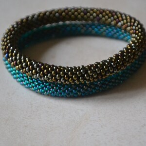 May include: A beaded bracelet with a gradient of blue, green, and gold beads.