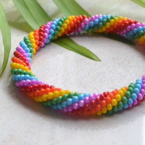 Puede incluir: Un brazalete de cuentas de colores arcoíris con un diseño en espiral.