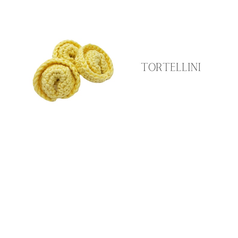 K&ouml;nnte beinhalten: Drei gelbe geh&auml;kelte Tortellini-Nudelformen auf wei&szlig;em Hintergrund. Das Wort "Tortellini" steht in schwarzer Schrift &uuml;ber der Pasta.