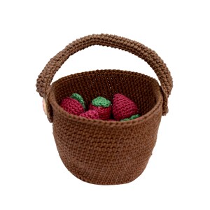 Puede incluir: Una cesta de crochet marr&oacute;n con asa llena de fresas de crochet rojas.